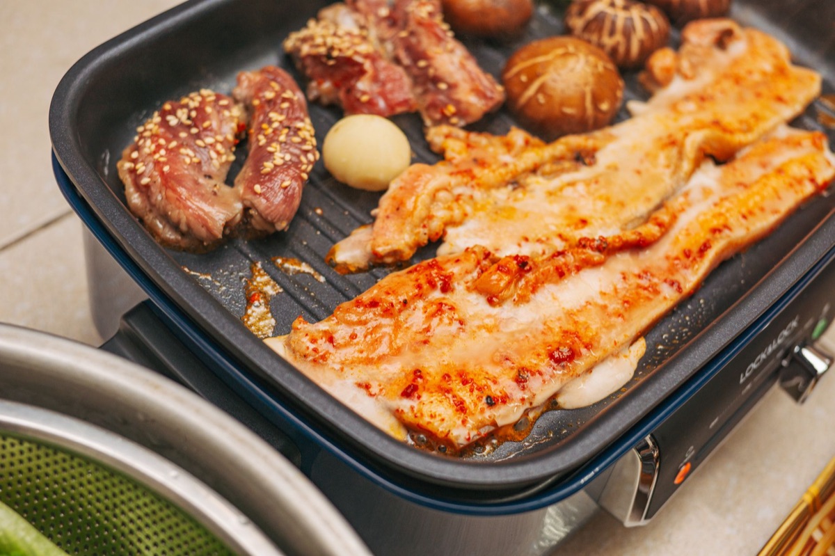삼겹살과 김치, 마늘이 놓인 한국식 고기 구이 재료