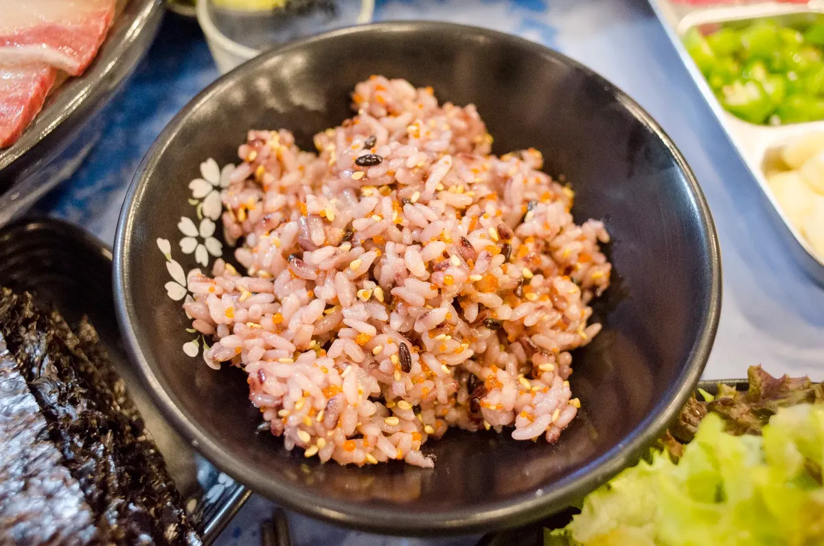 A tempting bowl of homemade Asian rice with side dishes, perfect for a nutritious meal.