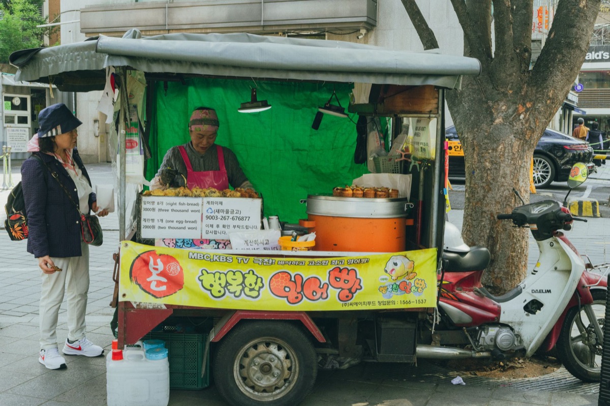 Um vendedor de comidas de rua coreana com sopa de kimchi e sanduíches de bulgogi